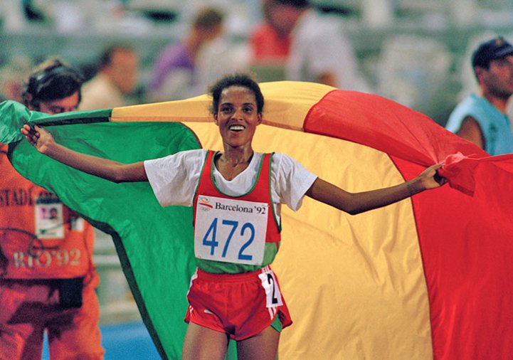 Photos Derartu Tulu [Éthiopie] défilant avec le drapeau de l’Éthiopie après sa victoire, photographie[nbsp]de[nbsp]Bob[nbsp]Thomas, 1992.
