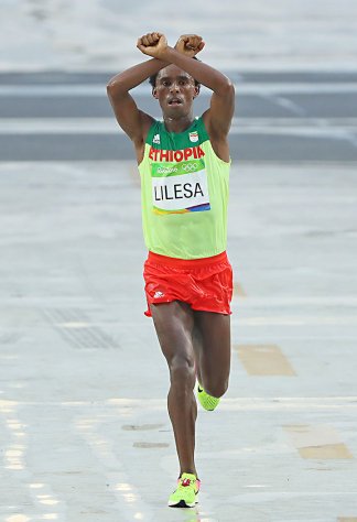 Feyisa Lilesa [Éthiopie], arrivé deuxième au[nbsp]marathon, croise ses poings au-dessus de sa[nbsp]tête en soutien aux manifestations contre le[nbsp]gouvernement éthiopien, photographie,[nbsp]2016.
